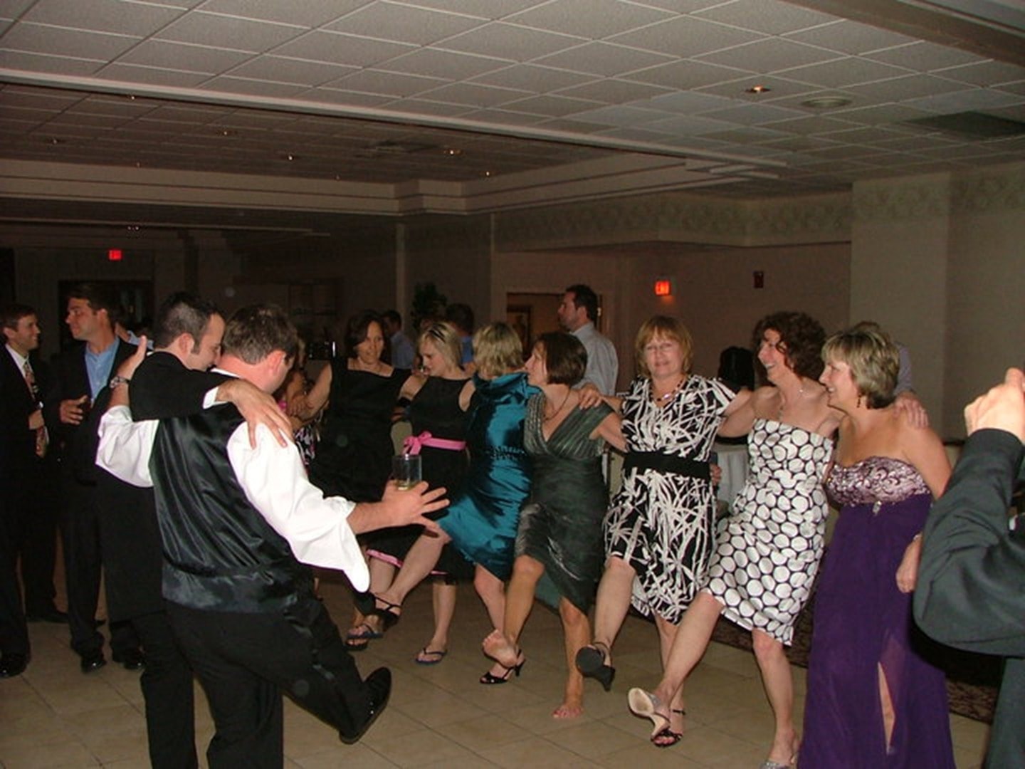 Wedding guests joining a line dance at a reception