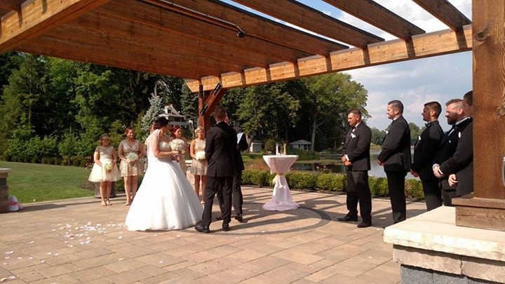 Outdoor wedding ceremony under a wooden pergola