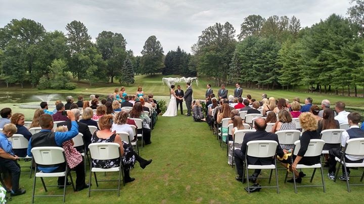 Outdoor wedding ceremony beside a pond