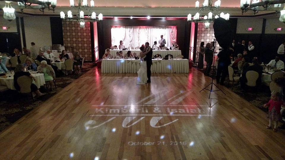 Wedding couple dancing at a formal reception with floor monogram lighting